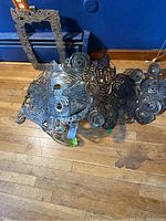 Sculpture and frame resting on hardwood floor showing overall shape and pattern