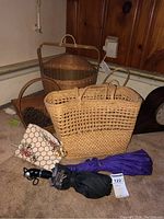 Photo showing two woven baskets, large woven tote bag, embroidered purse, and two umbrellas grouped together.
