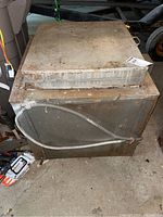 Top and side view of heavy metal ceramic kiln showing hinged insulated lid, rust and wear on surface.