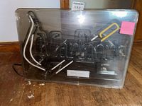 Front view of the rectangular neon sign with 'Marlboro' text in black, white, and yellow neon tubes inside a clear plastic casing.
