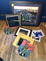 Photo of entire lot showing neatly stacked framed and unframed prints including aerial Fenway Park photo, TMNT posters, Pink Floyd album print, and others.