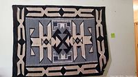 Full view of the Two Grey Hills Navajo rug showing entire geometric pattern and colors in black, gray, and beige.
