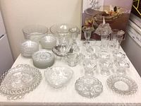 Overall view of vintage cut glass plates, bowls, ice cream cups, and lead crystal rose bowl in box arranged on table.