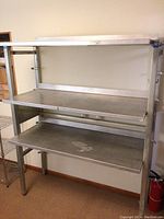 Front view of the industrial metal shelving unit showing three shelves and sturdy frame.