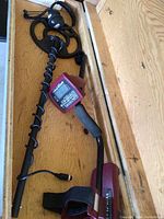 Detector assembly in wooden case showing search coil, control unit, handle and cable