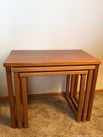 View of all three wooden nesting tables compactly nested together.