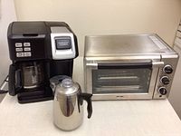 Photo showing Hamilton Beach FlexBrew coffee maker, Oster toaster oven, and stainless steel percolator side by side on a counter.