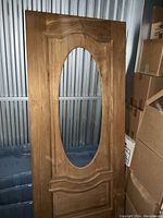 Full view of the mahogany door showing the oval cutout for the glass insert and the natural wood finish.