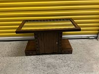 Photo of the entire coffee table showing the top and base against a yellow background.