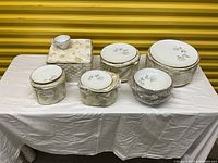 Full view of covered boxes and a tea cup arranged on a table, showing the packaging and some china pieces.