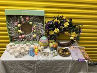 Overview of lot items on a table including wreaths, eggs, bunnies, and various decor