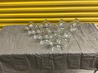 Photo showing all 10 star shaped clear glass dishes arranged on a grey cloth.