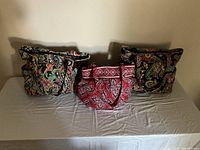 Front view of three Vera Bradley tote bags, one medium and two large, showing colorful quilted floral and paisley patterns