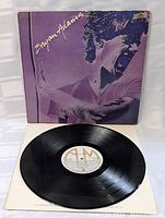 Vinyl record labeled A&M Records displayed with album cover behind, showing clean surface and label details.