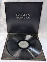 Vinyl record displayed resting on open cover showing label and vinyl grooves.