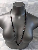 Front view of the necklace on a mannequin torso showing the full length and bead arrangement.