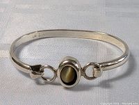 Full view of sterling silver bracelet showing central oval cabochon stone and linking ring details.