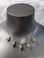 Full view of the sterling silver 16-inch necklace displayed on a mannequin neck showing the five distinctive tribal charms along the chain.