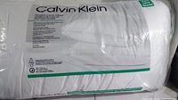 Photo showing the Calvin Klein branding and king size label on the sealed pillow package.