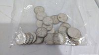 Clear plastic bag of approximately 30 silver quarters viewed from above
