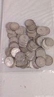 Multiple images of circulated silver Canadian dimes from 1967 or earlier, stacked and laid out in plastic bags.