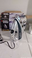 Front angled view of the Black & Decker professional steam iron next to the product box