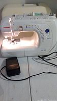 Front view of Janome PRL-18 sewing machine on table with foot pedal