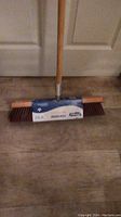 Front view of the broom head showing the label and bristles.