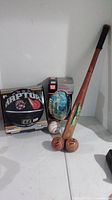 Photo showing all items: two baseballs, one baseball bat and two boxed balls (basketball and football)