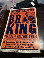 Front view of B.B. King 2010 Canadian tour poster showing large text and image of B.B. King with guitar, orange and blue colors, measuring approximately 14 by 22 inches. Poster shows slight edge wear.