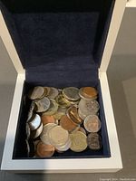 Coins inside the blue velvet-lined white box