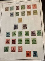 Photo of a collection of German postage stamps on album page labeled with denominations from 1923