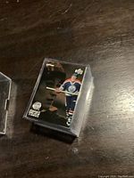 View of Wayne Gretzky hockey card in protective plastic case on a wooden surface.