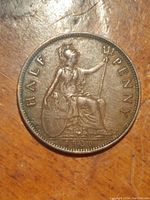 Close-up of reverse side of the 1936 British halfpenny coin showing Britannia seated with a trident and shield, date 1936 visible.