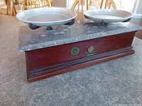 Side view showing marble top, original metal pans, wooden base with molding, and maker's marks/stickers on the front.