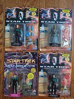 Four Star Trek action figures in original packaging: Deep Space Nine Dr. Julian Bashir, and various Generations characters including two identical Data figures and others.