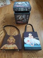 Photo of keepsake box and two Marilyn Monroe collectible purses on wooden floor.