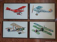 Four framed Martin Battersby prints of WWI and era fighter airplanes displayed on wooden floor