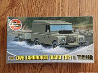 Box front showing LWB Land Rover hard top with trailer in water crossing