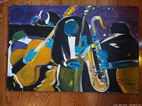 Frontal image of the oil painting showing three jazz musicians playing instruments, with signature visible.