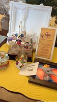 Full view of all items: 1998 Disney 75th Anniversary sculpture, two small snow globes, and Dumbo ceramic trivet.