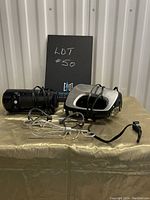 Two Black & Decker electric hand mixers showing one black and one stainless steel look unit, each with attached cords and several beaters in front.