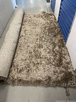 Partially unrolled view of rug lying on floor