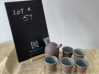 Japanese sake set with flask and five cups arranged on fabric