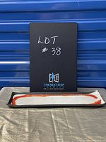 Photo of rectangular ceramic tray with black rim and cream, orange, brown mid-century modern design.