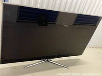 Front view of Samsung TV on chrome Y-shaped stand