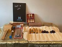Full view of the sculpting tool set spread on table showing wooden mallet, sharpeners, sculpting tools in fabric roll, and boxed small tools and stones
