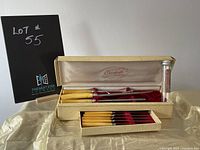 Original case holding carved cutlery set with a drawer of smaller cutlery pieces