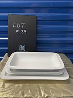 Three plain white rectangular serving trays nested inside each other showing different sizes and thickness.