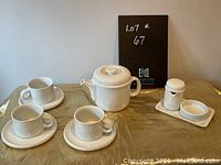 Full set including teapot, three cups with saucers, creamer and sugar bowl on a tray.